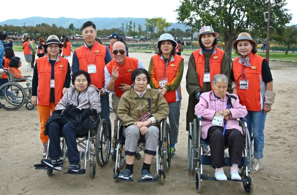 재가장애인들과 자원봉사들이 첨성대에서 가을을 만끽하며 기념촬영을 하고있다